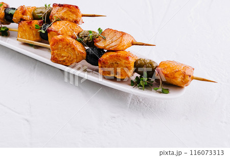 Gourmet grilled chicken skewers on white plate 116073313