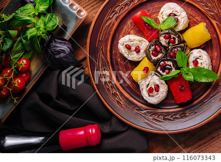 Gourmet stuffed eggplants and peppers with pomegranate and basil on wooden table Gourmet stuffed eggplants and peppers with pomegranate and basil on wooden table 116073343