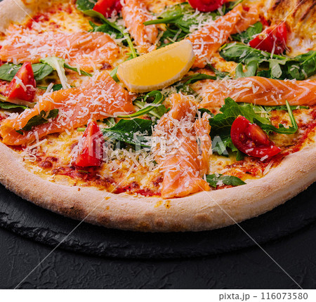 Gourmet smoked salmon pizza on dark background Gourmet smoked salmon pizza on dark background 116073580