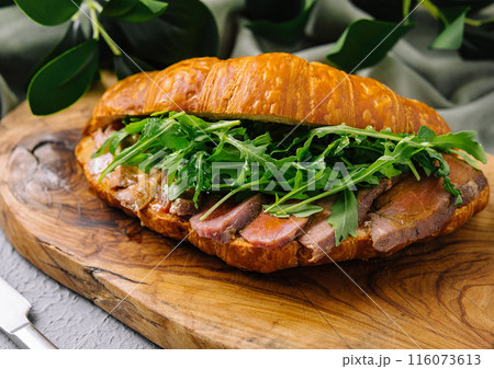 Gourmet croissant sandwich with arugula and ham 116073613