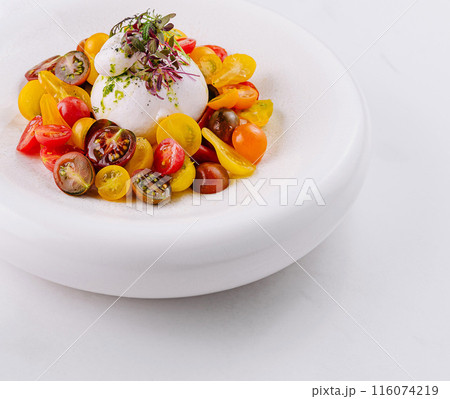 Gourmet burrata cheese salad on white plate 116074219