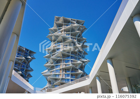 Modern residential building with geometric design against clear blue sky. City architecture with protruding triangular elements against clear blue sky 116075392