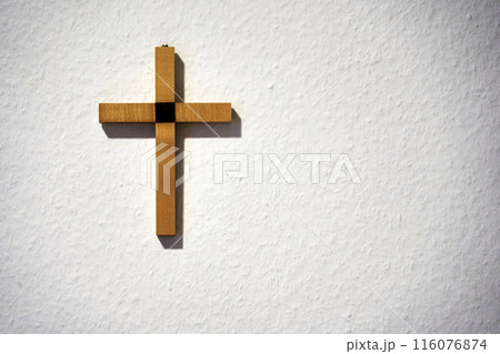 Wooden cross on a white wall 116076874