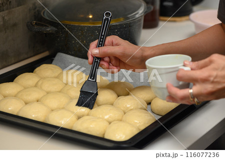 woman greases buns in the kitchen 4 116077236