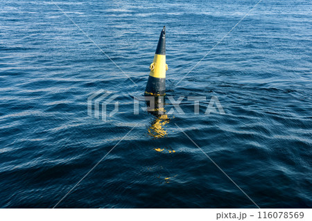 A view of a buoy in the river on a sunny day, east cardinal mark of danger A view of a buoy in the river on a sunny day, east cardinal mark of danger 116078569