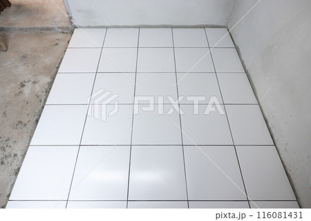 Tile floor under construction in room. Tile floor under construction in room. 116081431