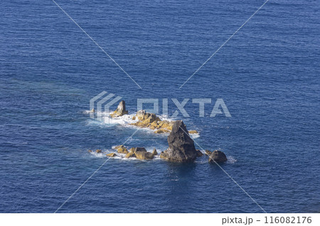 A rocky island sits in the middle of the ocean A rocky island sits in the middle of the ocean 116082176
