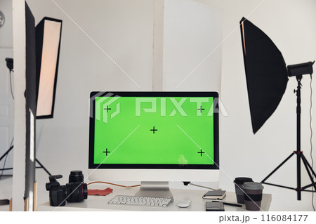 Minimal background image of computer with chroma key green screen on workplace table in photo studio with professional lighting equipment, copy space Minimal background image of computer with chroma key green screen on workplace table in photo studio with professional lighting equipment, copy space 116084177