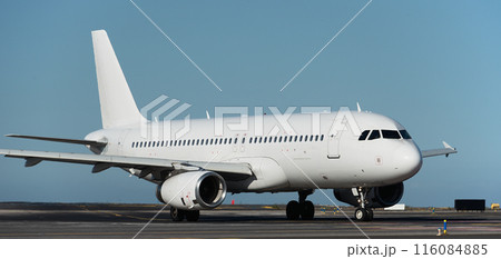 White plane to runway for take off, airplane taxiing for take off. White passenger jet plane taxiing along the runway in the airport 116084885