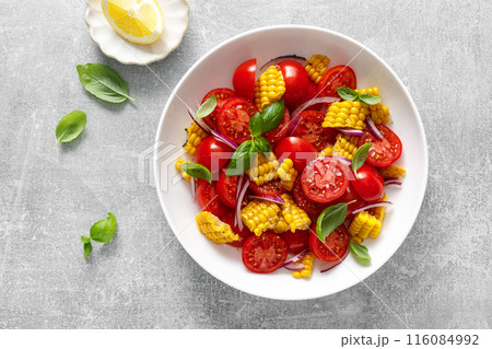 Tomato and corn salad with fresh basil, onion, dressed with olive oil. Mexican food, tomato corn salad Esquites, top view Tomato and corn salad with fresh basil, onion, dressed with olive oil. Mexican food, tomato corn salad Esquites, top view 116084992