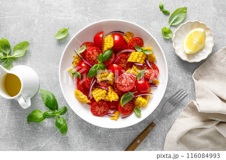 Tomato and corn salad with fresh basil, onion, dressed with olive oil. Mexican food, tomato corn salad Esquites, top view 116084993