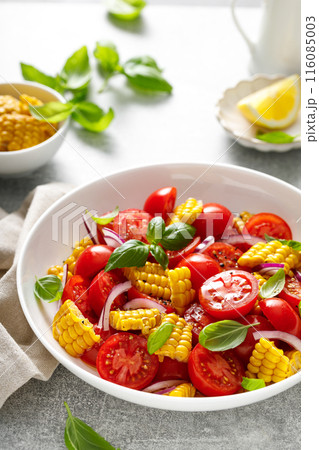 Tomato and corn salad with fresh basil, onion, dressed with olive oil. Mexican food, tomato corn salad Esquites Tomato and corn salad with fresh basil, onion, dressed with olive oil. Mexican food, tomato corn salad Esquites 116085003