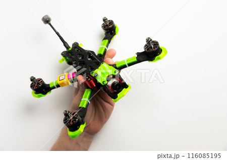Male hands holding a high-speed racing fpv helicopter drone. Studio photo on a white background 116085195