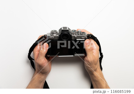 Digital SLR camera in retro style in male hands on a white background 116085199