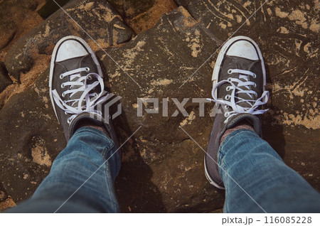 Casual sneakers on rock surface during outdoor adventure 116085228