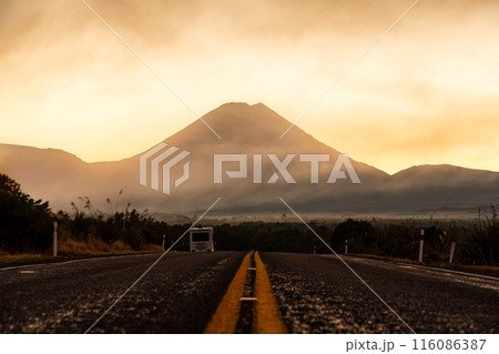 Volcanic Mount Ngauruhoe with golden sky in foggy over highway road at Tongariro national park, New Zealand Volcanic Mount Ngauruhoe with golden sky in foggy over highway road at Tongariro national park, New Zealand 116086387