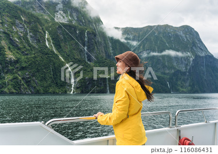 Asian woman enjoying the view of Milford Sound during ferry cruise on vacation at New Zealand Asian woman enjoying the view of Milford Sound during ferry cruise on vacation at New Zealand 116086431