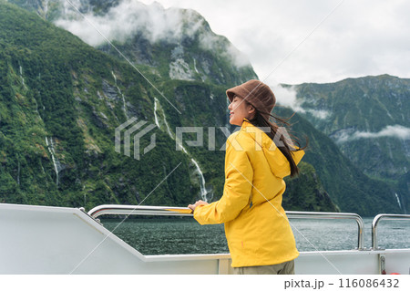 Asian woman enjoying the view of Milford Sound during ferry cruise on vacation at New Zealand Asian woman enjoying the view of Milford Sound during ferry cruise on vacation at New Zealand 116086432