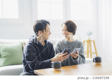 スマホを見る夫婦 スマホを見る夫婦 116087298