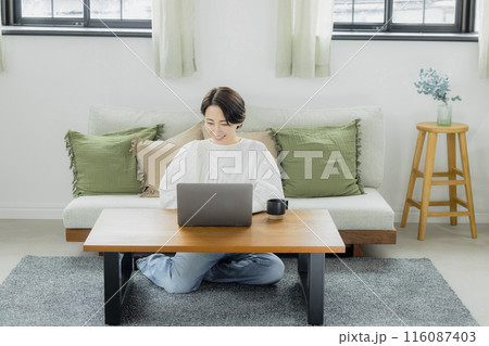 リビングでパソコンを見るミドルの女性 116087403
