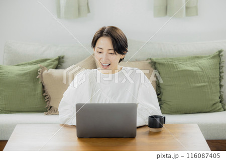 リビングでパソコンを見るミドルの女性 リビングでパソコンを見るミドルの女性 116087405