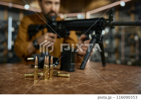 Closeup automatic rifle and bullets at weapon store Closeup automatic rifle and bullets at weapon store 116090353