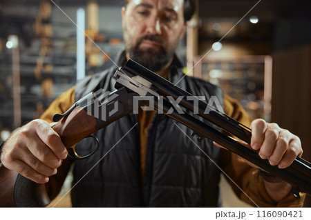Man working in weapon shop preparing high quality munitions for sale 116090421