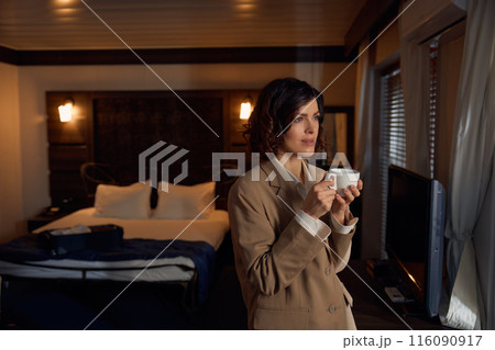 Portrait of thoughtful elegant business woman in hotel bedchamber 116090917