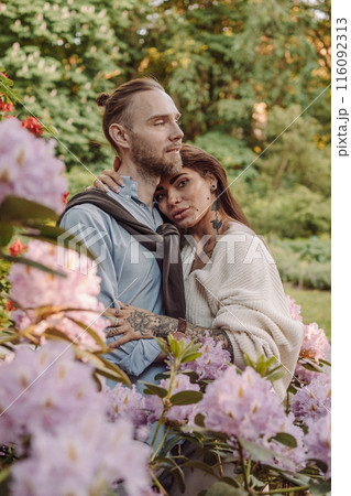 Young fun surprised couple family man woman in rest relax together boyfriend meet girlfriend. Close-up portrait of a girl with a freckled face standing and hugging his neck in the sunlight. 116092313