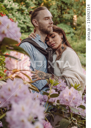 Young fun surprised couple family man woman in rest relax together boyfriend meet girlfriend. Close-up portrait of a girl with a freckled face standing and hugging his neck in the sunlight. 116092314