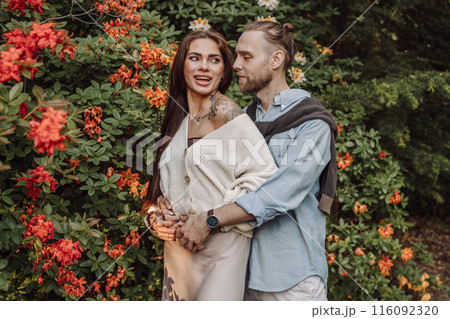Young fun surprised couple family man woman in rest relax together boyfriend meet girlfriend. Close-up portrait of a girl with a freckled face standing and hugging his neck in the sunlight. 116092320