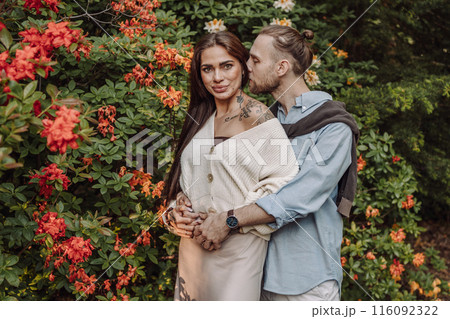 Young fun surprised couple family man woman in rest relax together boyfriend meet girlfriend. Close-up portrait of a girl with a freckled face standing and hugging his neck in the sunlight. 116092322