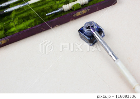Vintage pen and inkwell on paper background Vintage pen and inkwell on paper background 116092536