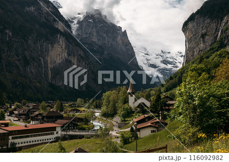 Discover a serene Swiss village embraced by mountains, offering an ideal setting for a peaceful alpine escape 116092982
