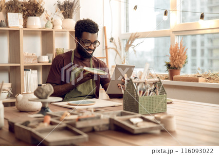 Dark-skinned sculptor demonstrating a new product on a webinar 116093022