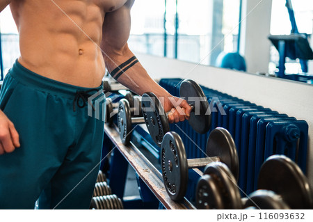 Bodybuilder holding a dumbbell in the gym 116093632