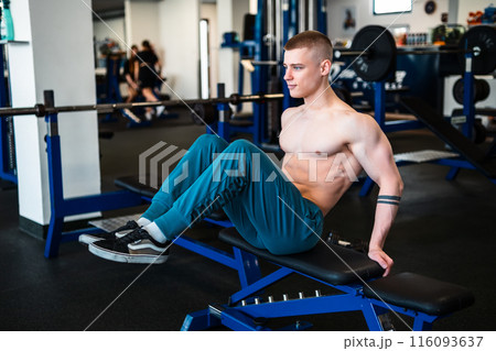 A professional bodybuilder works out his abs at the gym.  116093637