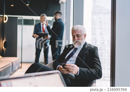 Senior businessman using smartphone in office 116095769