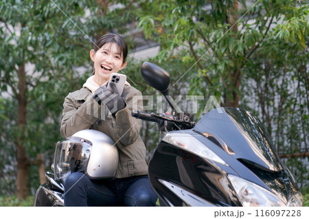 スマホを見て笑顔の女性ライダー スマホを見て笑顔の女性ライダー 116097228