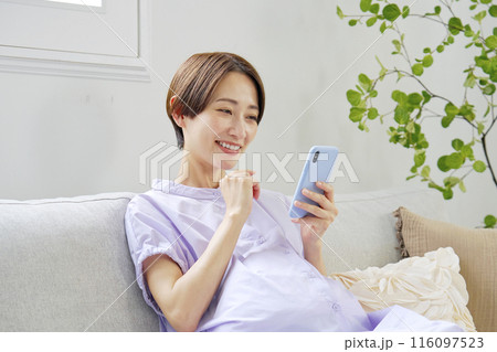 自宅でスマートフォンを使う高廉妊娠をした妊婦 自宅でスマートフォンを使う高廉妊娠をした妊婦 116097523