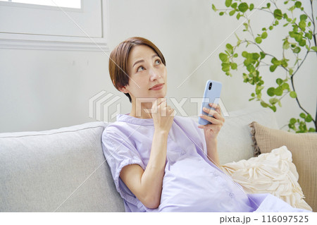 自宅で考えながらスマートフォンを使う高廉妊娠をした妊婦 カメラ目線 自宅で考えながらスマートフォンを使う高廉妊娠をした妊婦 カメラ目線 116097525
