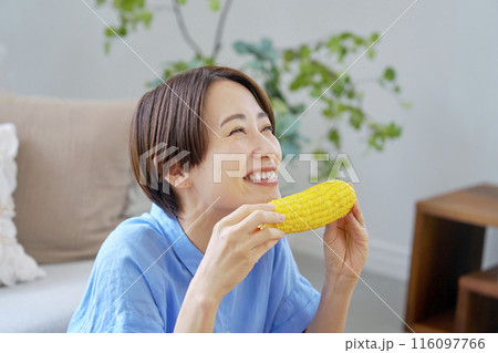 自宅でとうもろこしを食べる女性 116097766