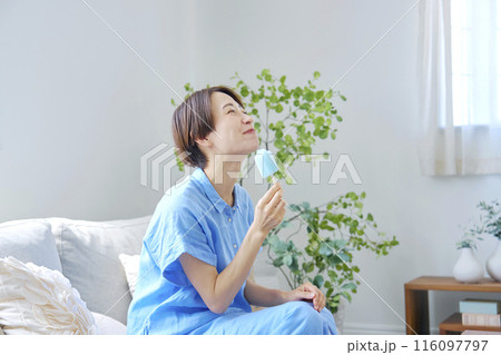 自宅で棒アイスを食べる女性 116097797
