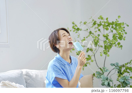 自宅でアイスキャンディーを食べる女性 116097798