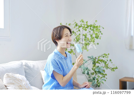 自宅でアイスキャンディーを食べる女性 116097799
