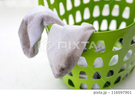 Dirty white socks in laundry basket 116097901
