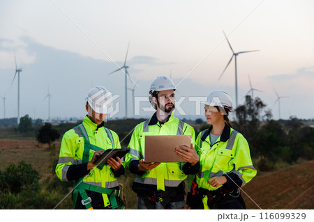 Team engineer wearing safety uniform holding laptop discussed plan about renewable energy Team engineer wearing safety uniform holding laptop discussed plan about renewable energy 116099329