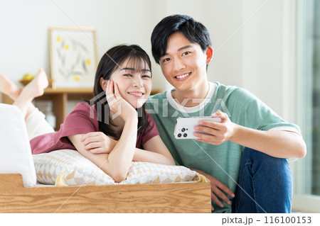 スマホで動画を見る若いカップル 116100153