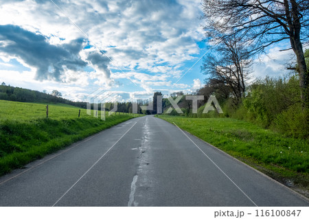 Enjoy a tranquil drive along a beautiful countryside road beneath a stunning sky Enjoy a tranquil drive along a beautiful countryside road beneath a stunning sky 116100847