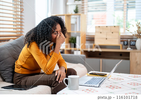 A stressed, unhappy Black woman is working from home, worried about her job, facing problems. 116101718
